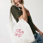 Femme portant un tote bag blanc imprimé