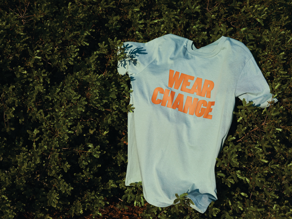 T-shirt bleu clair avec texte orange sur herbe