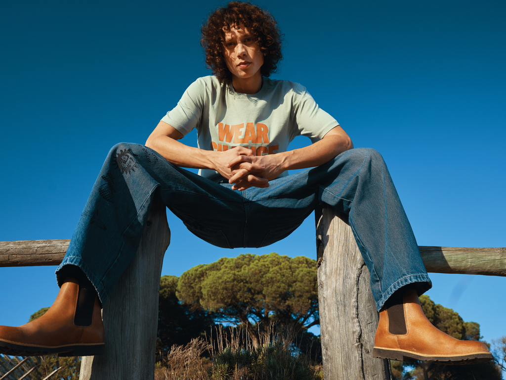 Personne assise dehors portant jean et bottines marron