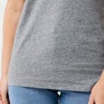 Personne portant un t-shirt gris et jean bleu