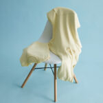 Sweat jaune pâle posé sur une chaise blanche