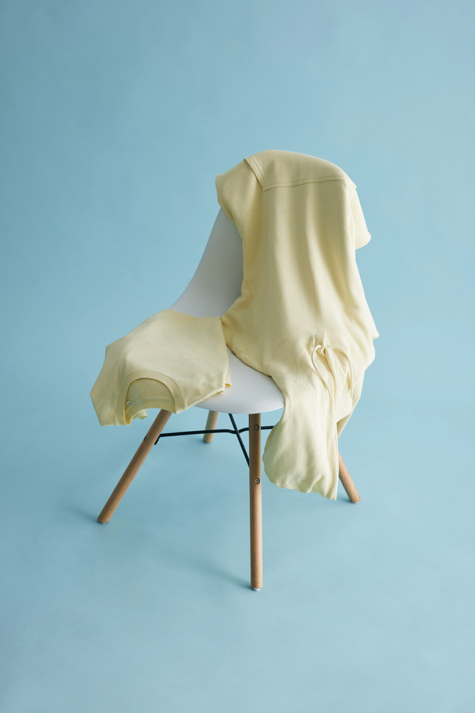 Sweat jaune pâle posé sur une chaise blanche