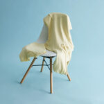 Sweat jaune posé sur chaise blanche design
