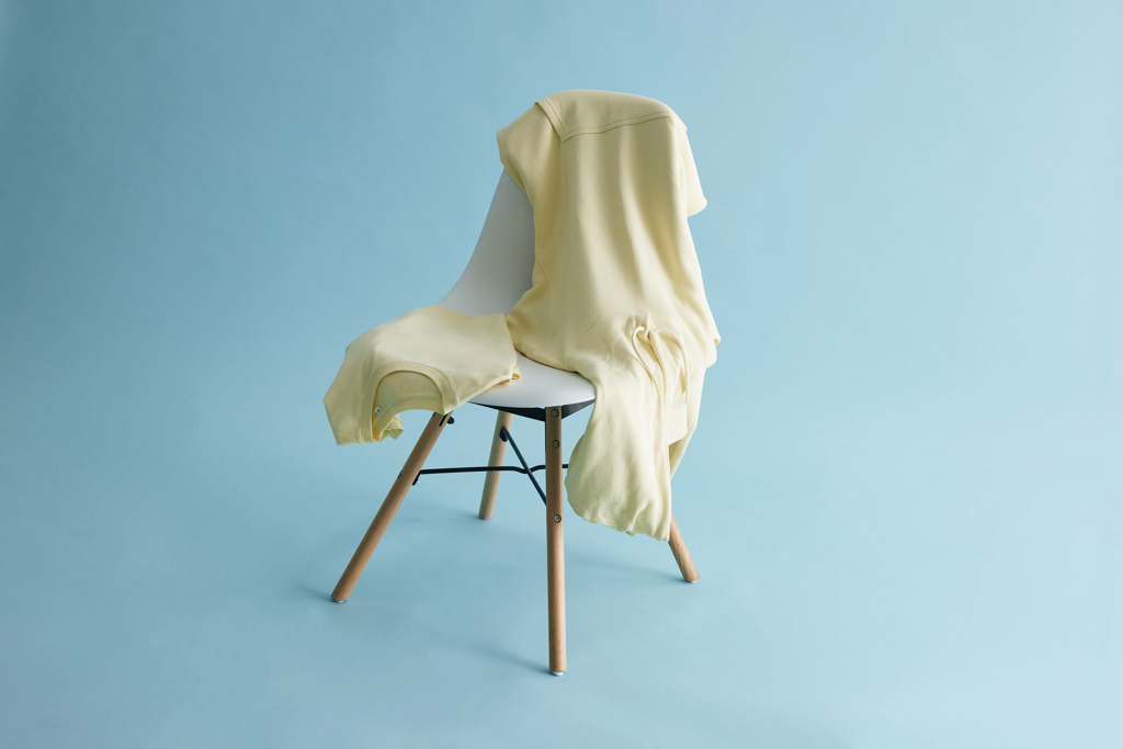 Sweat jaune posé sur chaise blanche design