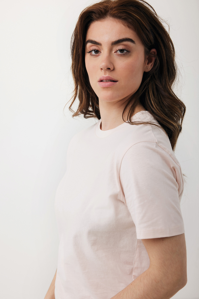 Personne portant un t-shirt rose pâle simple