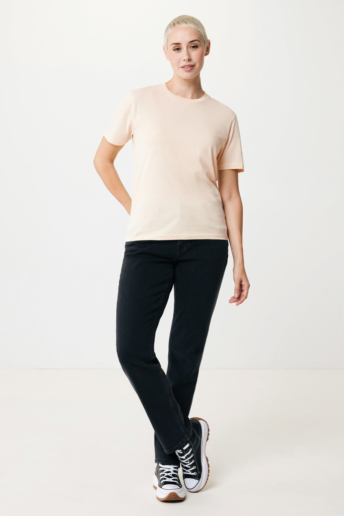 Personne portant un t-shirt beige et jean noir