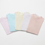 T-shirts pliés couleurs pastel sur fond blanc