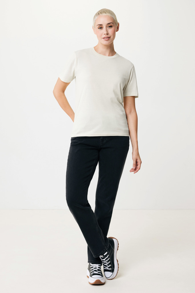 Personne portant t-shirt beige et jean noir.