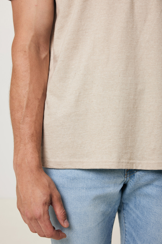 Main d’homme portant jean et t-shirt beige