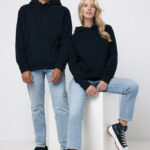 Deux personnes portent des sweats noirs et jeans clairs