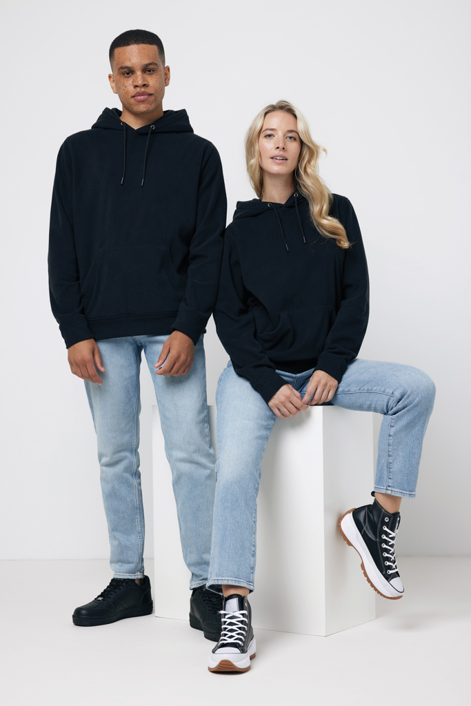 Deux personnes portent des sweats noirs et jeans clairs