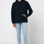 Homme portant un sweat noir et un jean clair