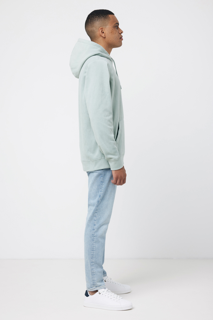 Homme portant sweat à capuche vert et jean clair