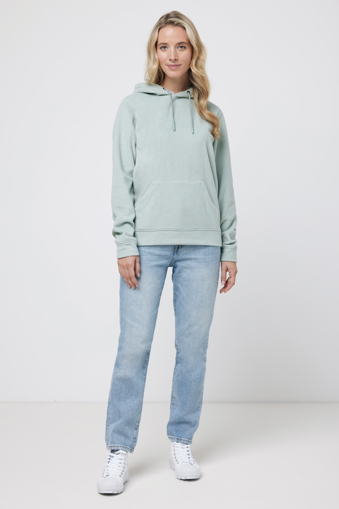 Femme portant un sweat vert et un jean.