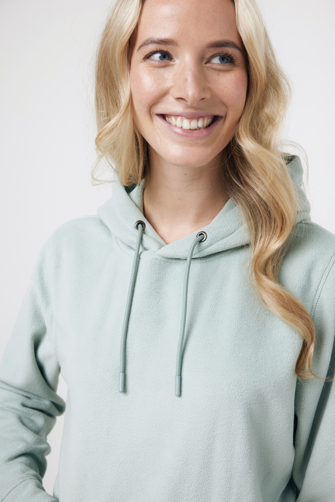 Femme souriante portant un sweat à capuche vert clair
