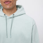 Personne portant un sweat à capuche vert clair