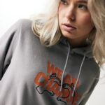 Femme portant un sweat gris à capuche imprimé