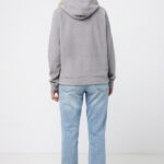 Personne portant un sweat gris et jean bleu