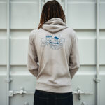 Personne portant un sweat à capuche beige illustré.
