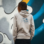 Personne portant un sweat à capuche devant graffiti coloré