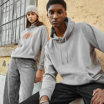 Deux personnes portent des sweats gris décontractés.
