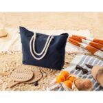 Sac de plage bleu marine sur le sable.