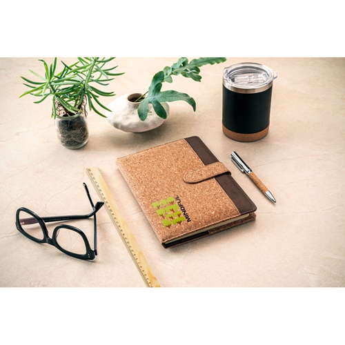 Bureau avec carnet en liège, plante et tasse réutilisable
