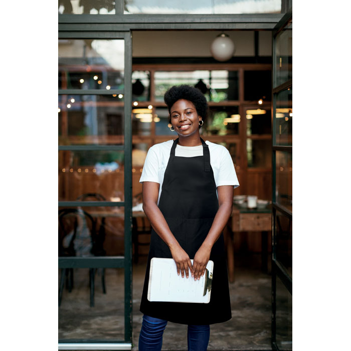 Serveuse souriante devant un restaurant moderne
