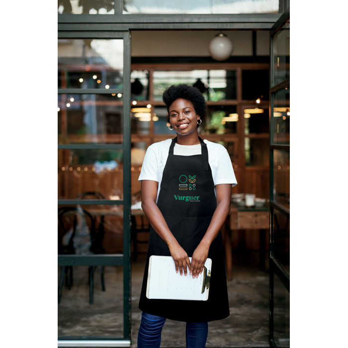 Serveuse souriante devant un restaurant végétarien.