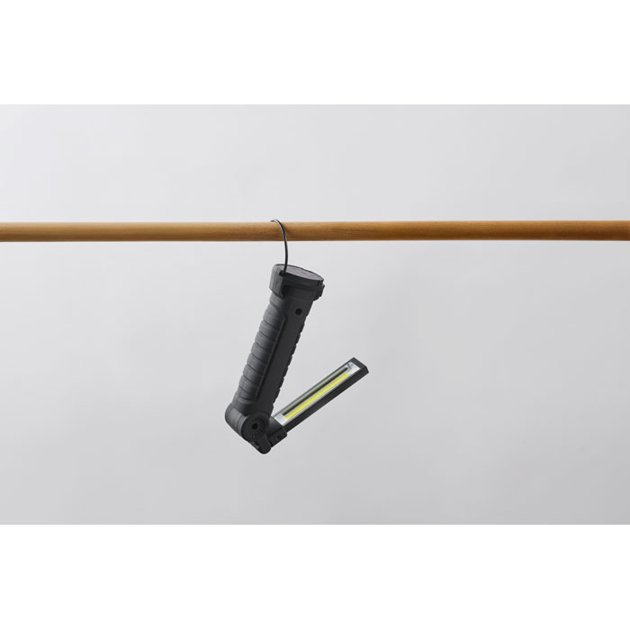 Lampe torche noire suspendue à une barre en bois