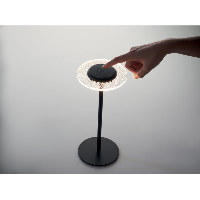 Main allumant une lampe de bureau moderne