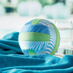 Balle bleue et verte sur serviette turquoise