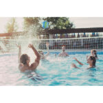 Groupe jouant au volley dans une piscine