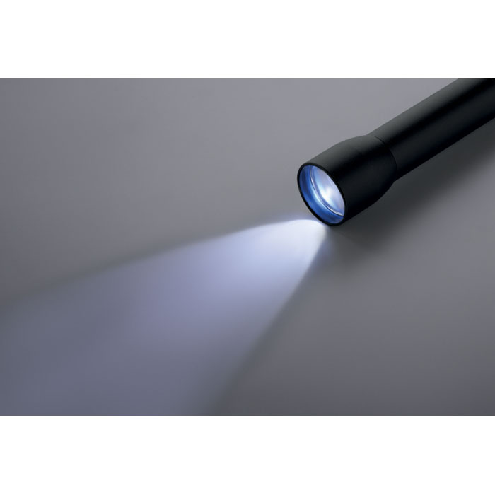 Lampe de poche noire allumée sur fond gris