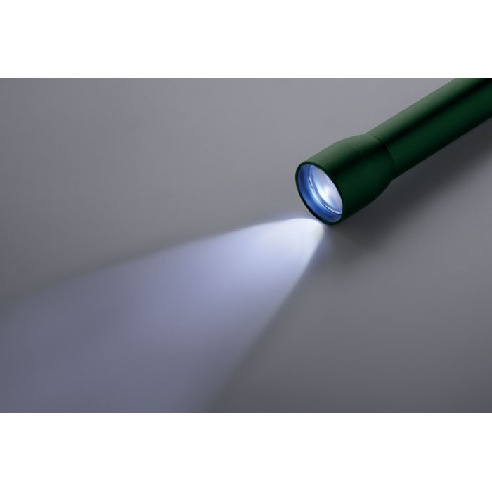 Lampe de poche verte allumée sur fond gris.