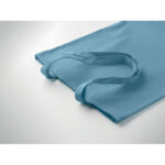 Sac en tissu bleu posé sur surface blanche