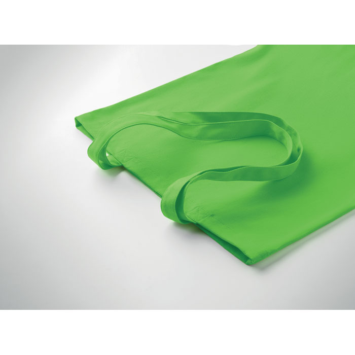 Sac cabas vert en tissu sur surface blanche