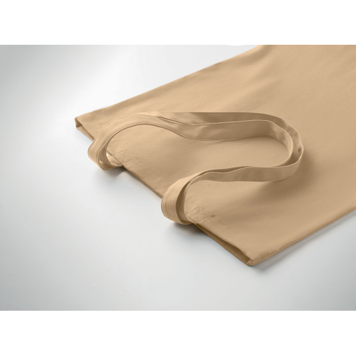 Sac en toile beige posé sur surface blanche