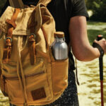 Randonneur avec sac à dos beige et gourde