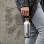 Personne tenant une gourde en acier inoxydable