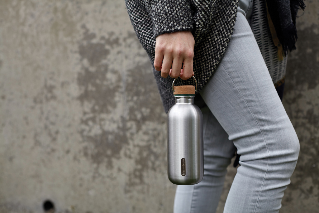 Personne tenant une gourde en acier inoxydable