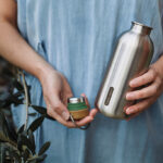 Personne tenant une gourde en acier inoxydable.