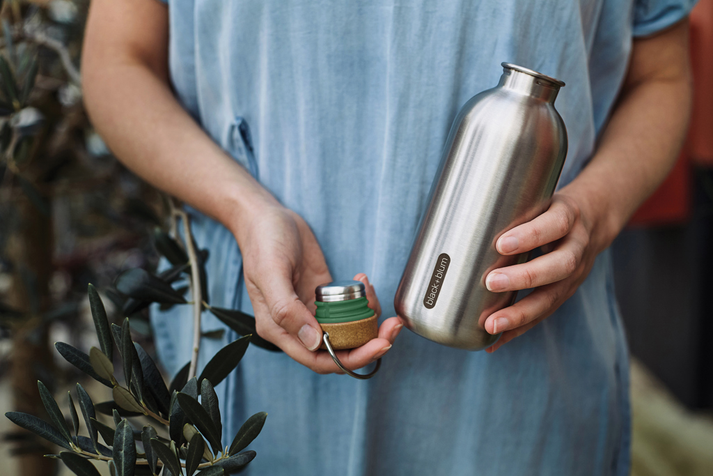 Personne tenant une gourde en acier inoxydable.