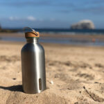 Gourde en acier sur plage ensoleillée