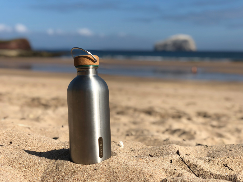 Gourde en acier sur plage ensoleillée