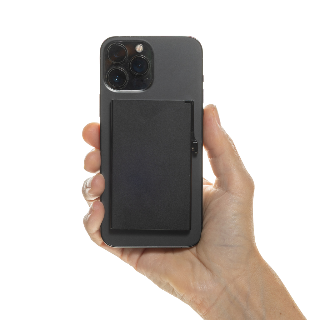 Main tenant un smartphone noir avec accessoire au dos
