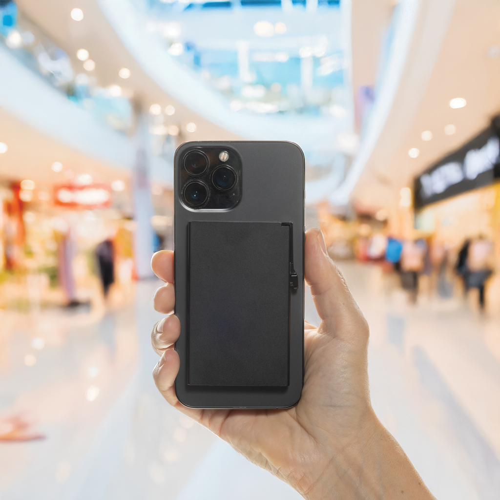 Main tenant un smartphone dans un centre commercial