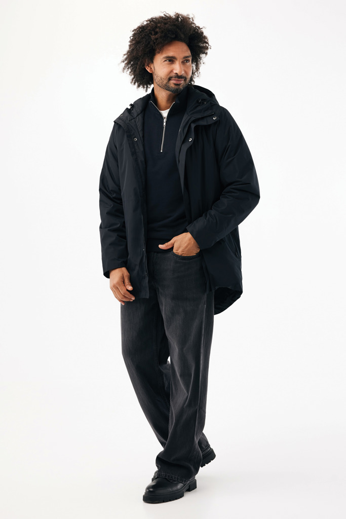 Homme portant manteau noir et pantalon ample