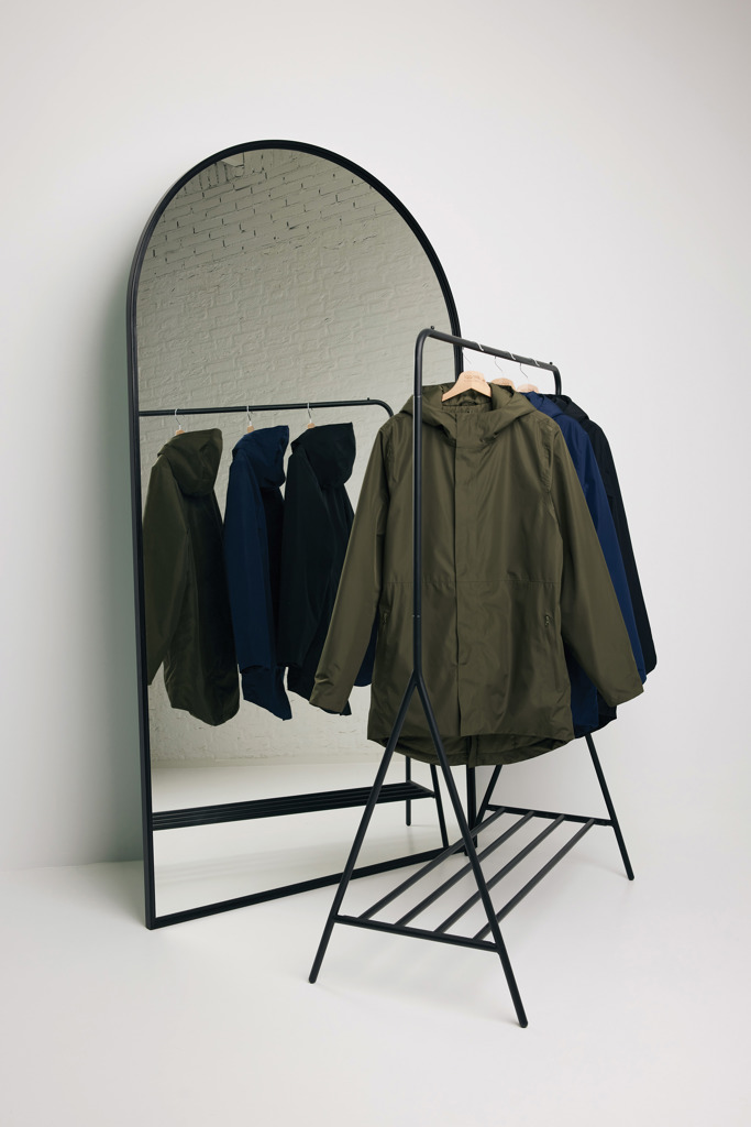 Manteaux suspendus devant un grand miroir.