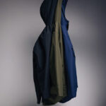 Veste à capuche bicolore verte et bleue suspendue